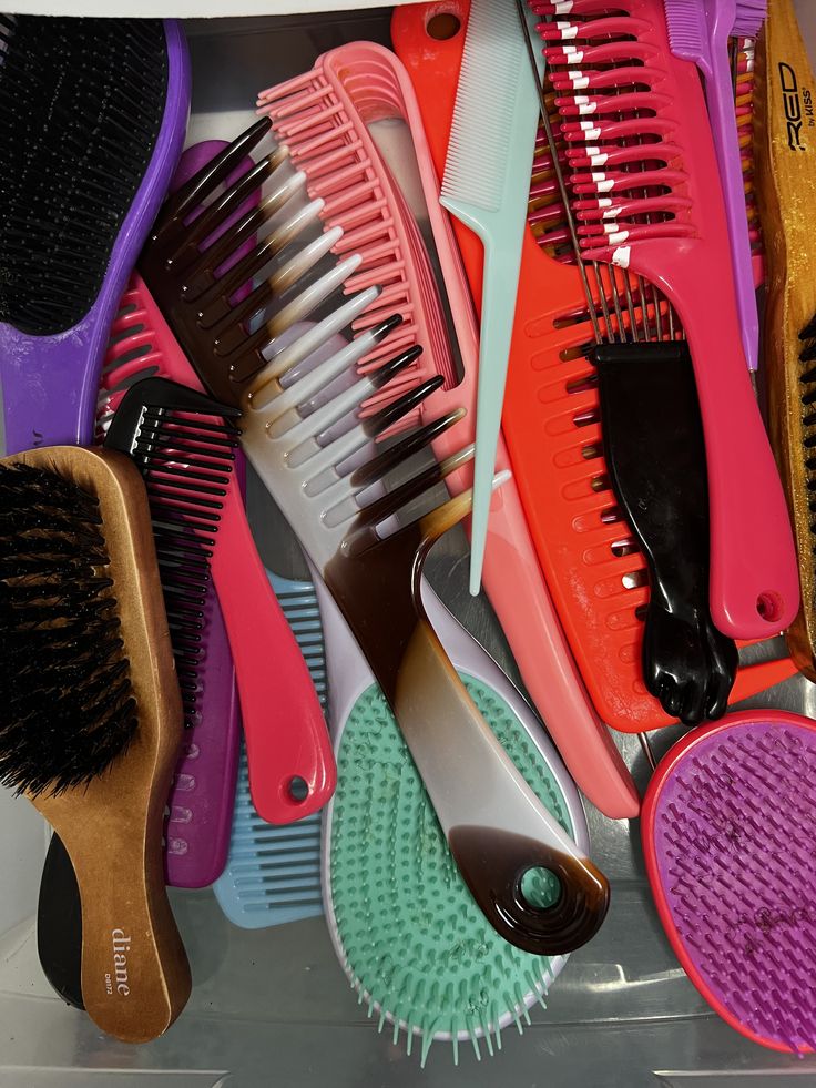 Table of assorted combs and brushes, including wide-tooth combs suited for detangling.