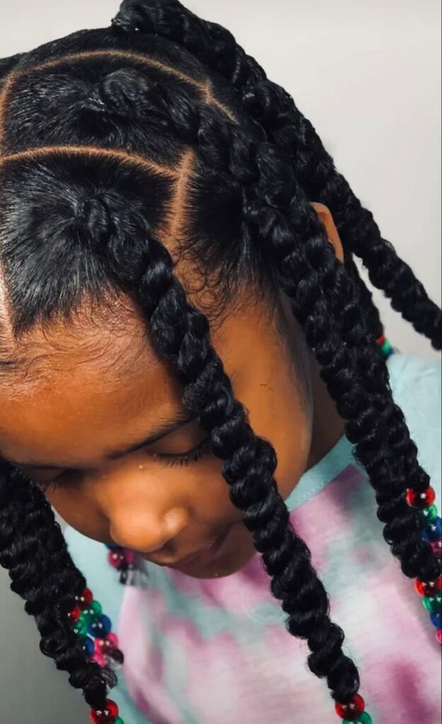 Child with jumbo twist hairstyle with colorful beads to accessorize