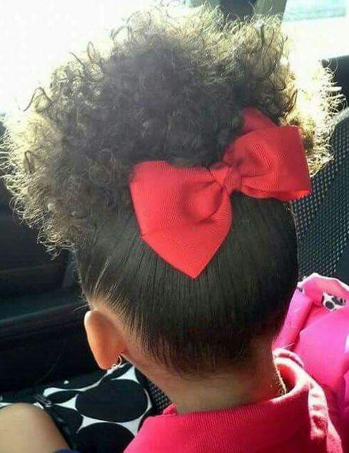 Toddler with high curly puff and large red bow