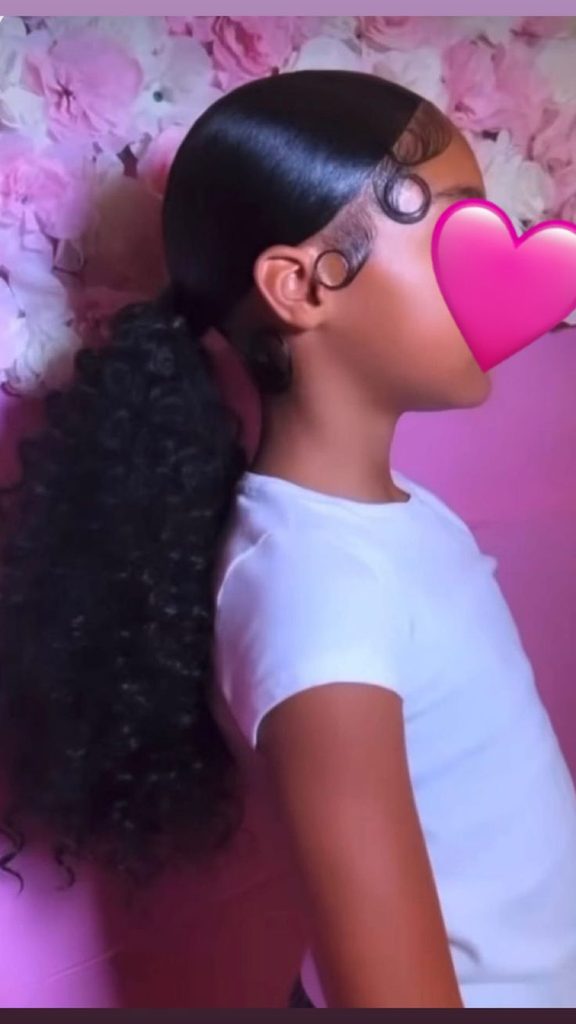 Little girl with a low curly ponytail hairstyle