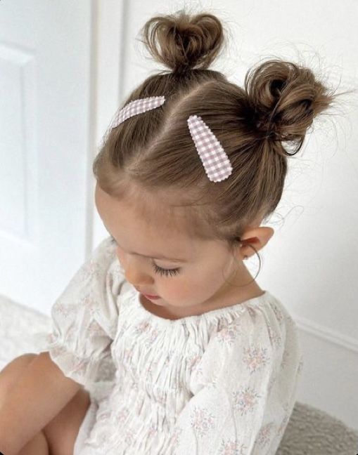 Toddler with two small space buns and gingham clips