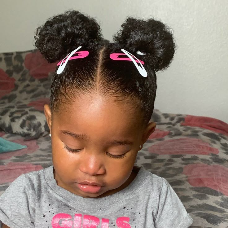 Natural double buns with center part on coily hair