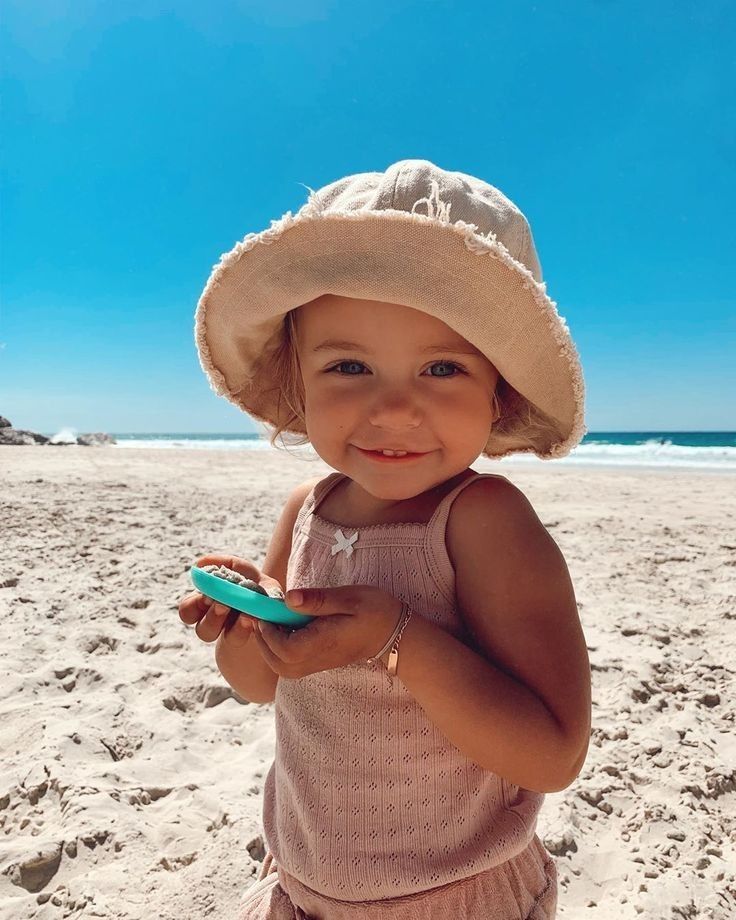 Smiling child in a sun hat at the beach