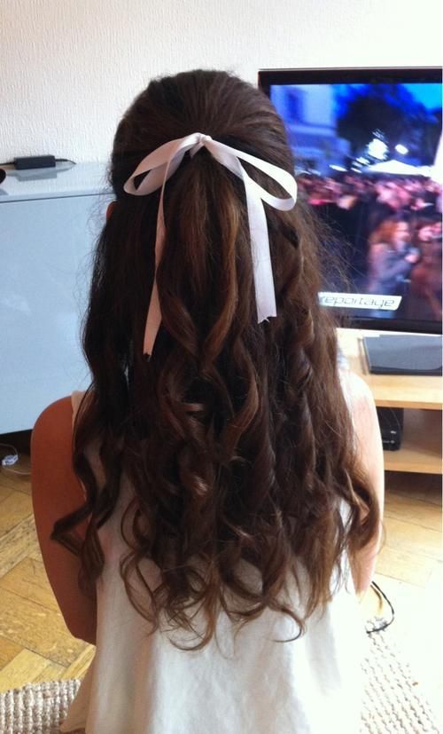Long curled hair tied with a white ribbon at the crown, ribbon ends hanging loose, shown from behind