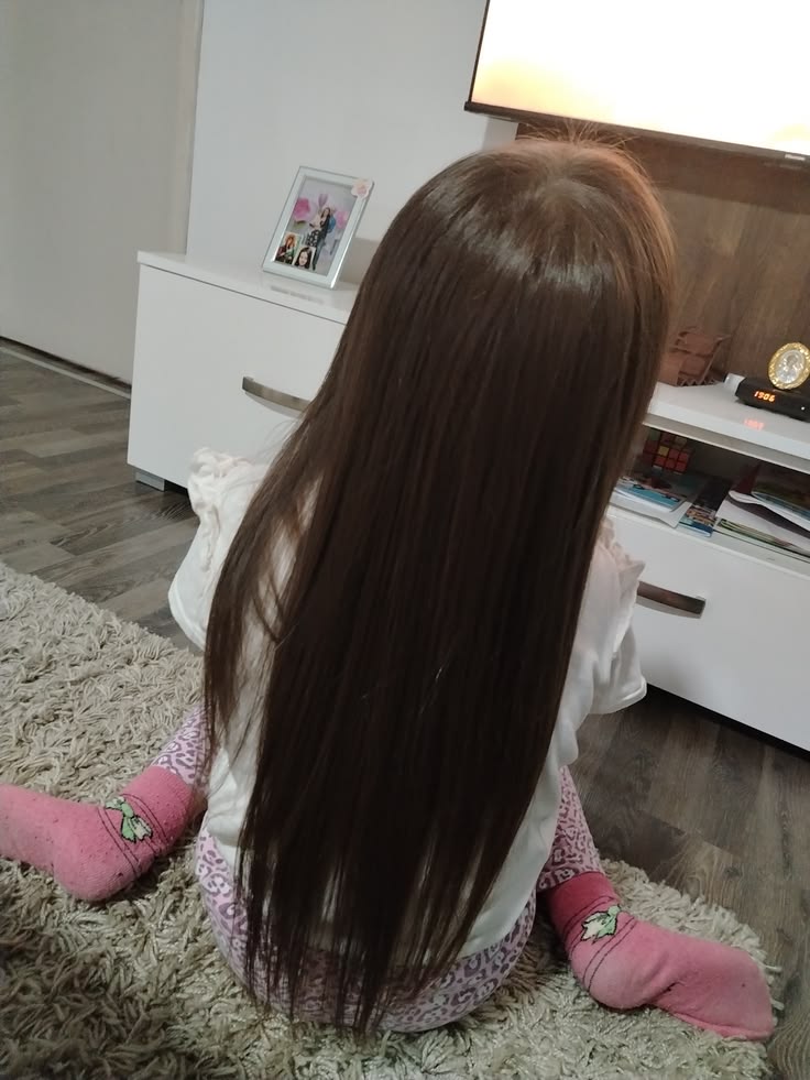 Young girl with long, smooth straight hair, shown from behind