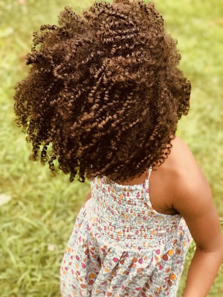 Close-up of a young girl's voluminous curly hair outdoors