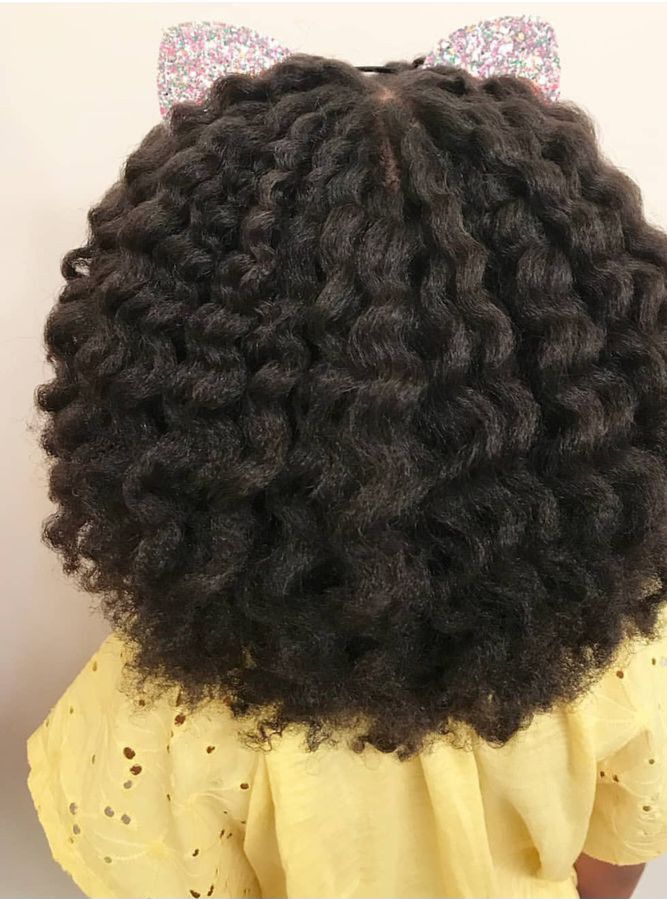Close-up of a twist-out hairstyle with sparkly bow clips at the crown, shown from behind