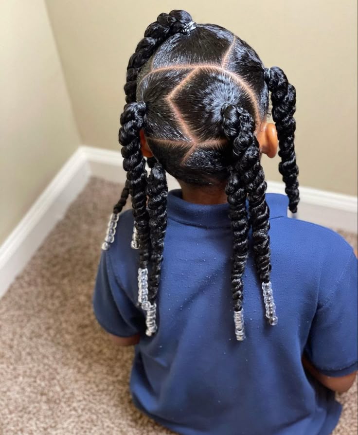 Young girl with jumbo two-strand twists sectioned in a star pattern, silver ring cuffs at the ends
