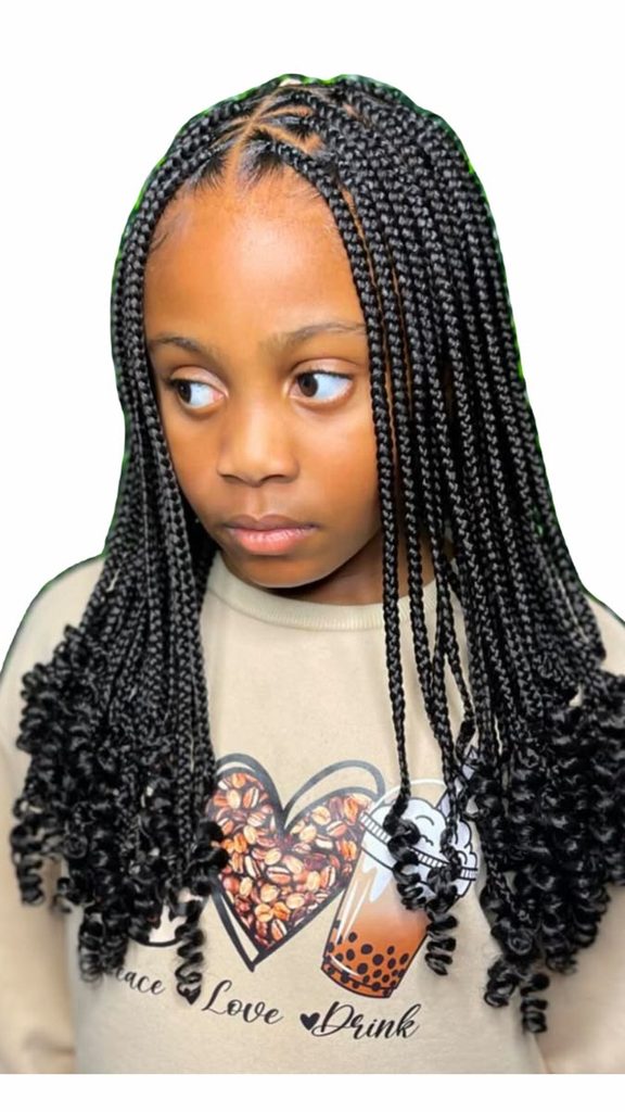 Young girl with knotless braids and curly ends, shown looking to the side