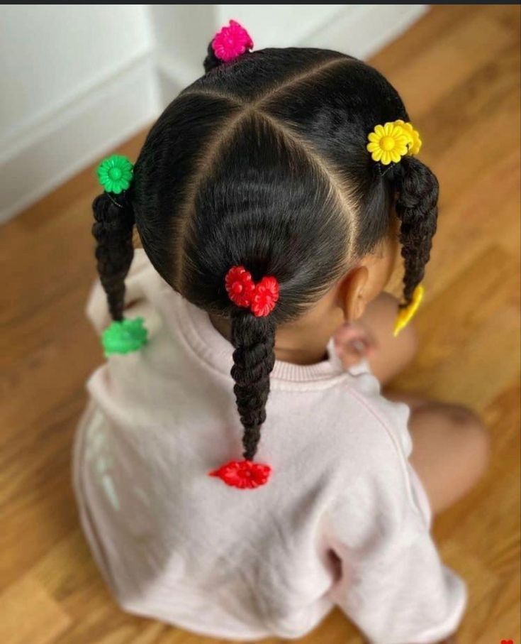 Girl with four twisted sections secured with colorful flower hair ties.