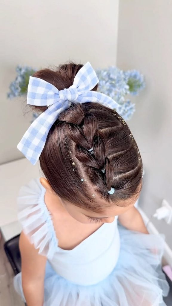 Girl with a pull-through braid leading into a bun, tied with a gingham bow, wearing a ballet tutu