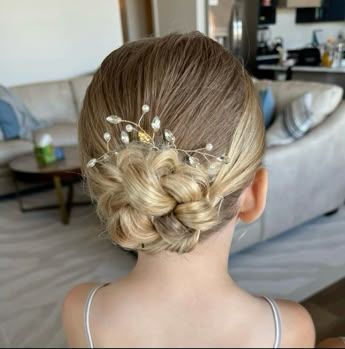 Girl with a knotted low bun at the nape decorated with a pearl hair pin.