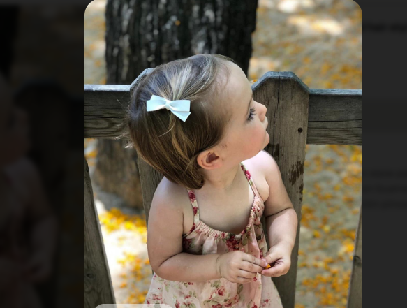 Toddler with hair swept to the side and a small bow clip