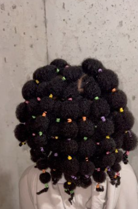 Child with tiny bubble puffs and colorful beads covering the head