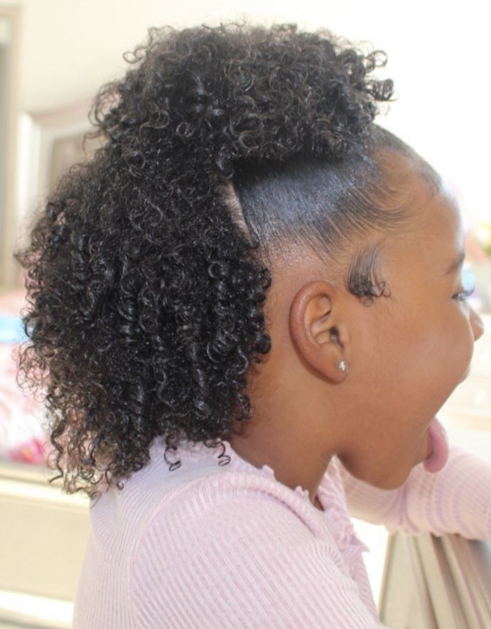 Child with curly hair pulled into a half-up protective style, showing sleek edges."