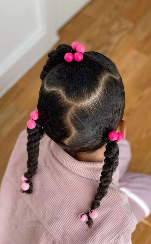 Overhead view of a girl with three twisted sections secured by colorful pink bubble hairties