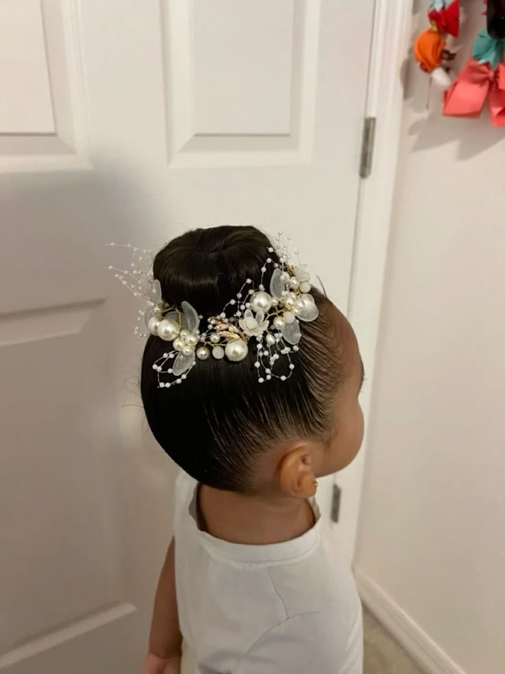 Young girl with a sleek high bun decorated with a pearl and floral hairpiece