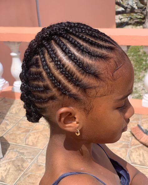 Close-up of a child's intricate cornrow braids styled outdoors.